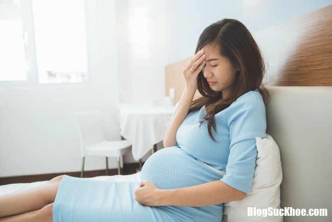 pregnant lady with a headache sits on bed low blood pressure 15217678194222038918057 Thiếu máu làm tăng gấp đôi nguy cơ tử vong ở thai phụ