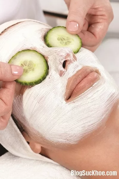 Natural facial treatment, young woman laying with facial mask and cucumber on eyes.